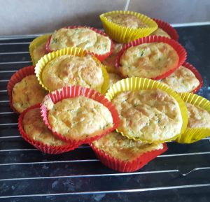 Courgette and Cheese muffins sitting on a cooling rack. Courgette and Cheese muffins all placed on a cooling rack