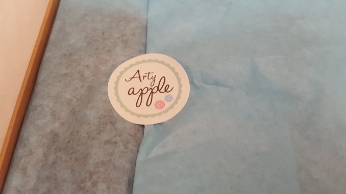 Tissue paper with a sticker of the arty apple logo