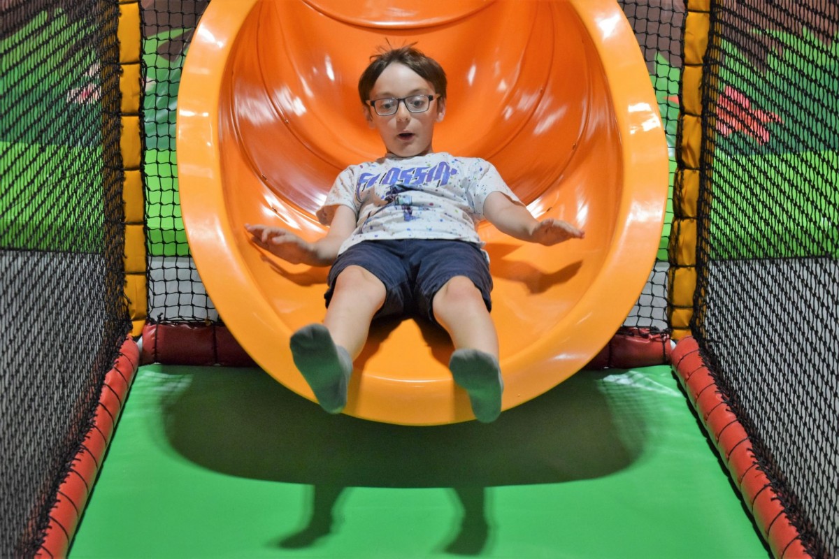 child at the bottom of the volcano slide